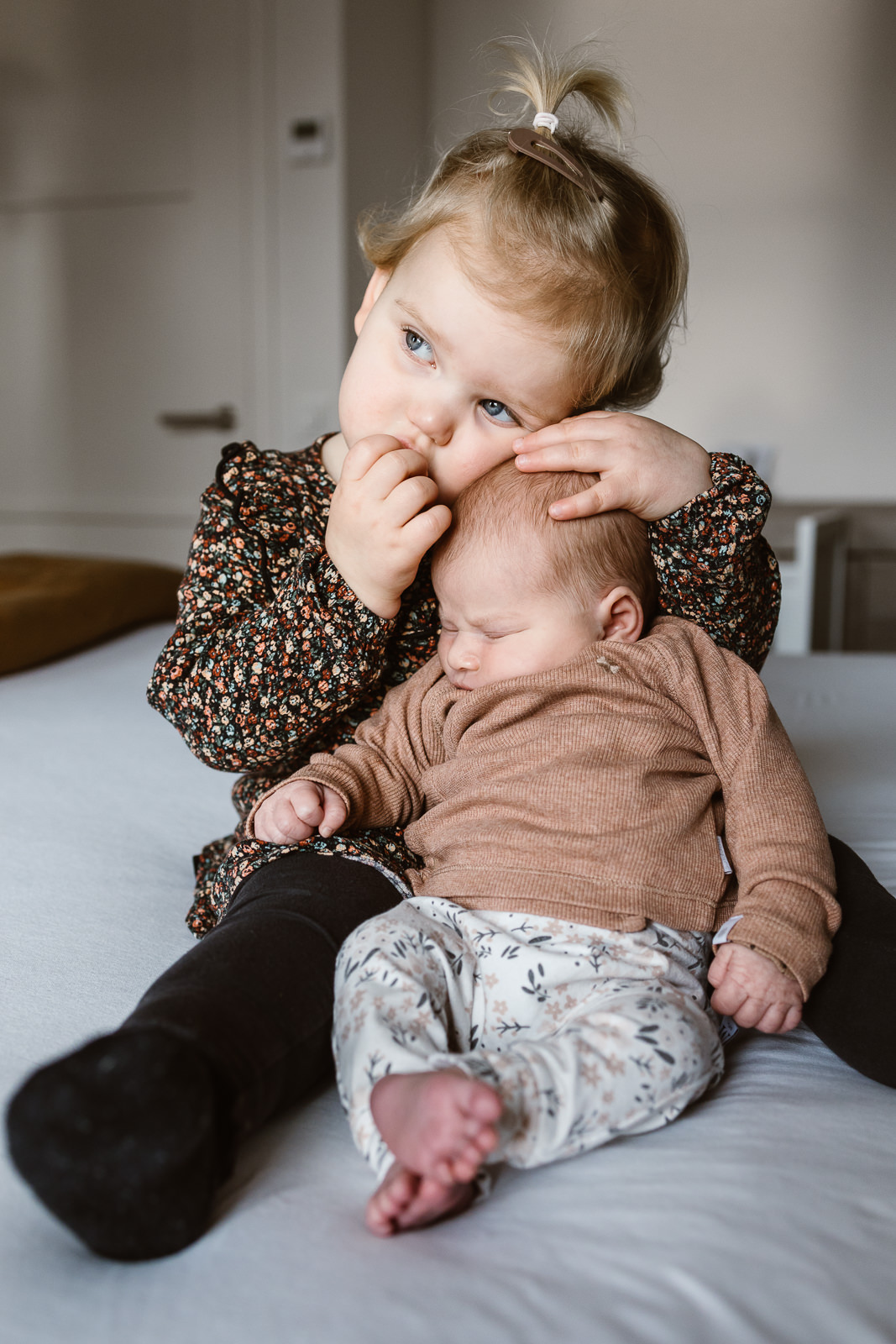 denise-van-duren-eerste-jaar-babyshoot Grote zus die haar newbornzusje knuffelt